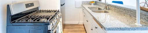 A kitchen with a blue stove and white cabinets.