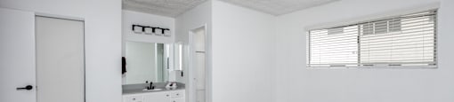 the living room of an apartment with white walls and wood flooring