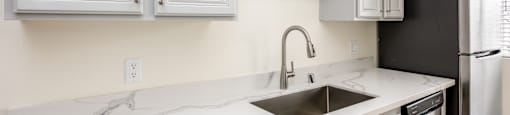 a kitchen with white cabinets and a sink