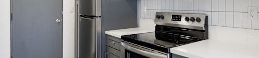 a kitchen with stainless steel appliances and white cabinets