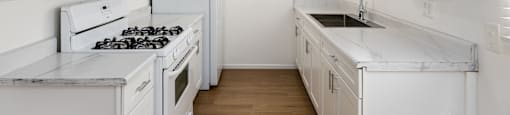 a kitchen with white cabinets and white appliances