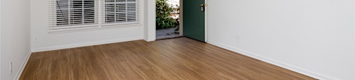 a bedroom with hardwood floors and white walls