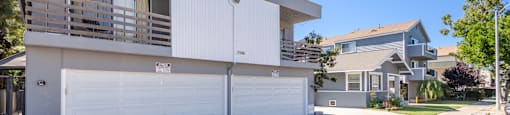 A two-story house with a white garage door.