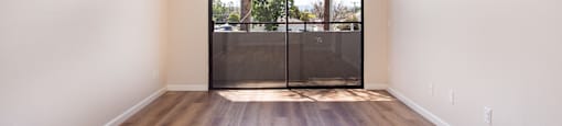 A room with a sliding door leading to a balcony.