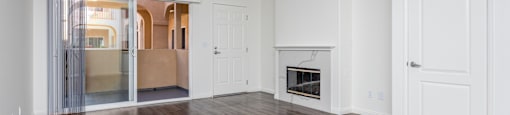 a bedroom with hardwood floors and white walls