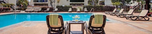 a swimming pool with lounge chairs and a coffee table