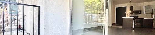 A patio with a black gate and sliding glass doors.