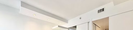 A spacious room with white walls and a tiled floor.