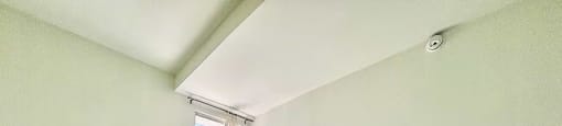 A room with white walls and a tiled floor with a window.