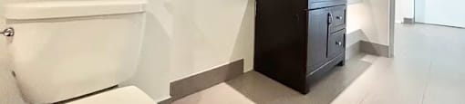 A white toilet sits next to a white sink in a bathroom.