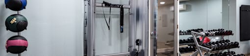 a gym with weights and a mirror and a glass door