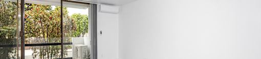 an empty living room with white walls and a sliding glass door