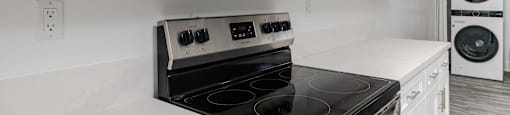 a kitchen with white cabinets and a stove and microwave