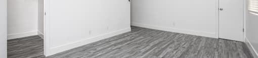 an empty living room with white walls and wood flooring
