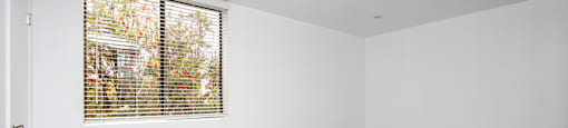 an empty room with white walls and a window