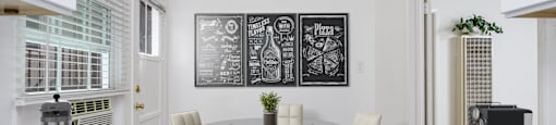 a kitchen with a table and chairs and a chalkboard on the wall