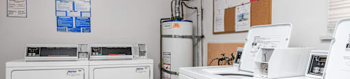 a laundry room with two washers and two washing machines