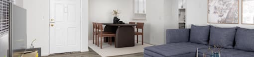 a living room with a blue couch and a dining room