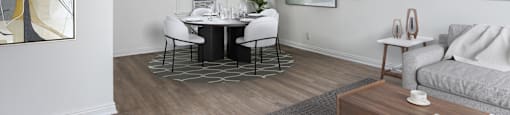 a living and dining room with white walls and a wood floor