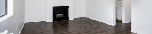 an empty living room with white walls and a fireplace