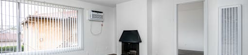 an empty living room with wood floors and a fireplace