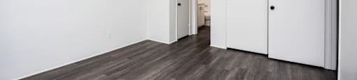 an empty living room with white walls and wood flooring