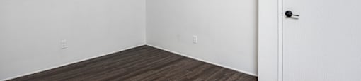 an empty room with white walls and a ceiling fan