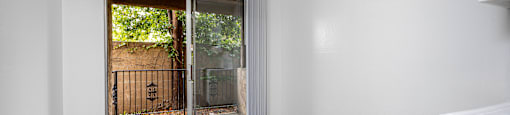 an empty room with a sliding glass door to a yard