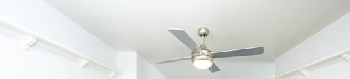 a living room with white walls and a ceiling fan