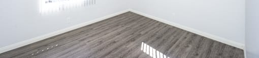 an empty bedroom with a ceiling fan and two windows