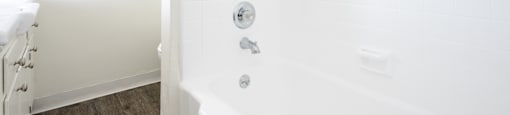 a white bathroom with a tub and a window