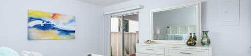 a bedroom with a bed and a dresser and a mirror