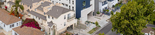 A modern building with a blue accent wall is surrounded by other buildings and houses.