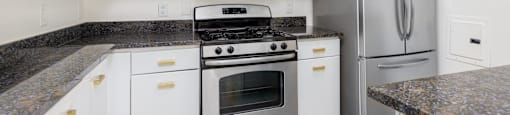 a kitchen with white cabinets and stainless steel appliances
