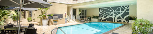 A large outdoor pool area with a table and chairs.