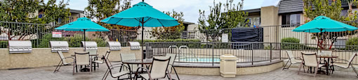 a patio with tables chairs and umbrellas