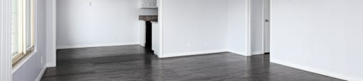 an empty living room with white walls and wood floors