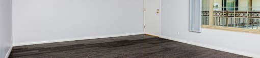an empty living room with white walls and wood flooring