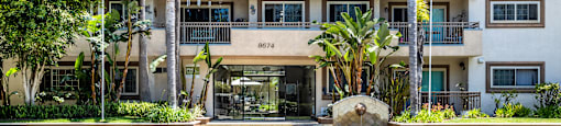 an apartment building with palm trees in front of it