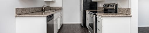 an empty kitchen with white cabinets and stainless steel appliances
