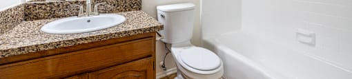 a bathroom with a sink toilet and tub and a mirror