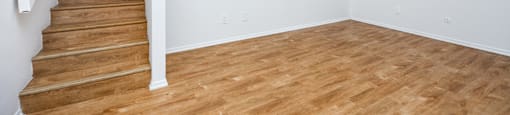 an empty living room with a hard wood floor and stairs