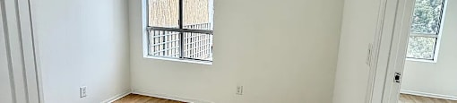 A room with wooden flooring and a window.