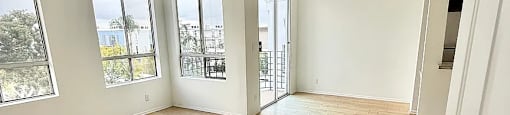 A room with wooden flooring and white walls.