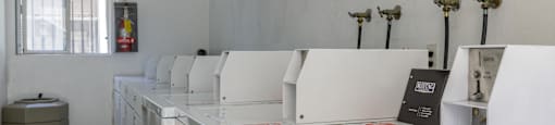 a row of washers and dryers in a laundry room