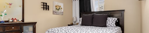 a bedroom with a bed and a dresser and a window