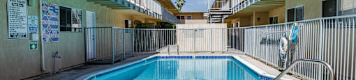 a swimming pool in a building with a fence around it