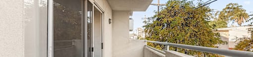 A balcony with a glass door and a metal railing.