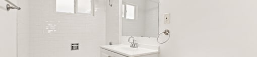 A white bathroom with a tub, sink, and toilet.