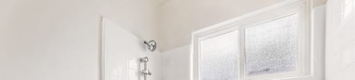 A white bathroom with a tub, shower, and toilet.